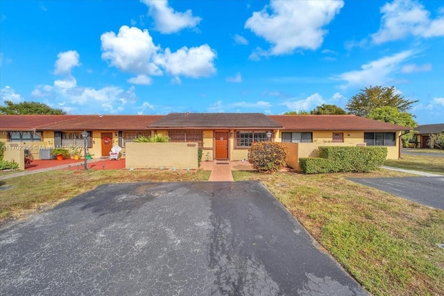 ranch-style house featuring cooling unit and a front lawn