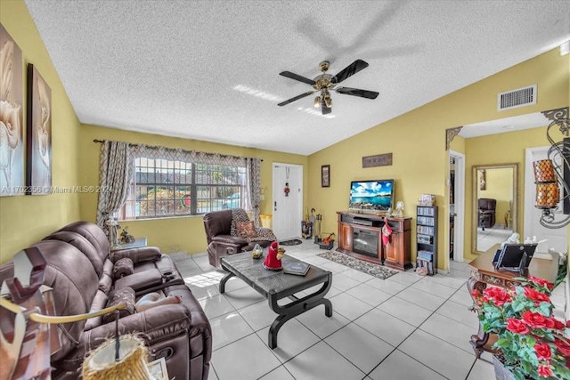 tiled living room with ceiling fan, a textured ceiling, and vaulted ceiling