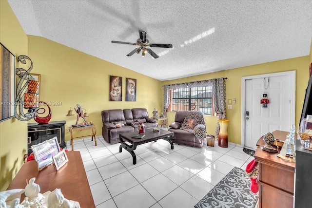 living room featuring vaulted ceiling, ceiling fan, light tile patterned floors, and a textured ceiling