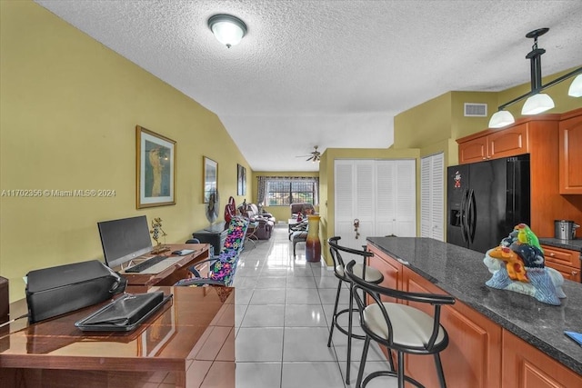 kitchen featuring ceiling fan, a textured ceiling, vaulted ceiling, black fridge with ice dispenser, and light tile patterned floors