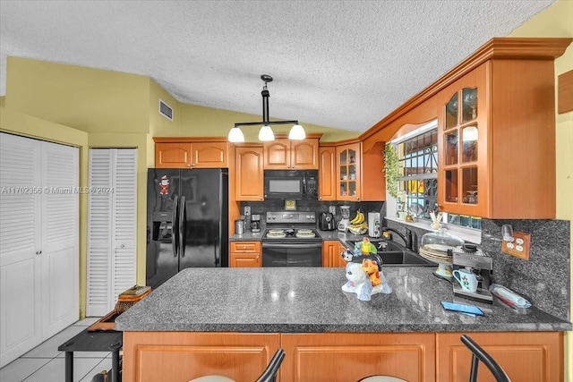 kitchen featuring light tile patterned floors, tasteful backsplash, vaulted ceiling, and black appliances