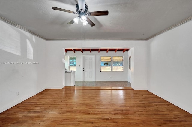 spare room with ceiling fan, hardwood / wood-style floors, a textured ceiling, and beam ceiling