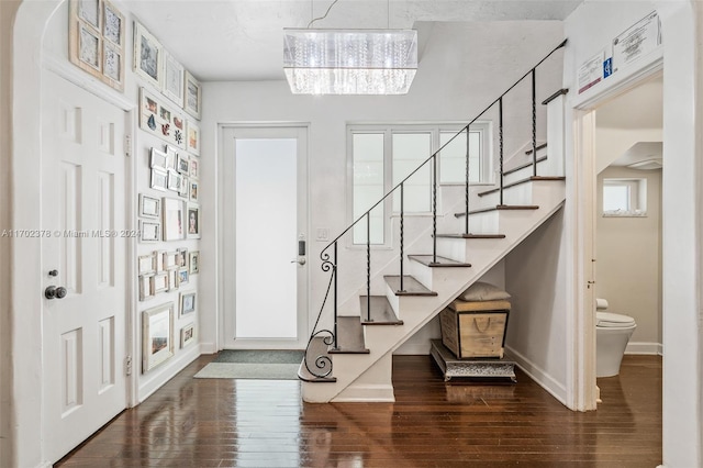 entrance foyer with a notable chandelier and dark hardwood / wood-style flooring