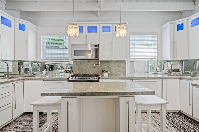 kitchen with white cabinets, a healthy amount of sunlight, a breakfast bar area, and appliances with stainless steel finishes