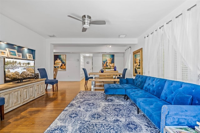 living room with ceiling fan and dark hardwood / wood-style flooring