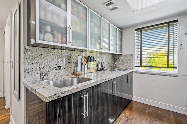 kitchen featuring decorative backsplash, sink, a healthy amount of sunlight, and dark hardwood / wood-style floors