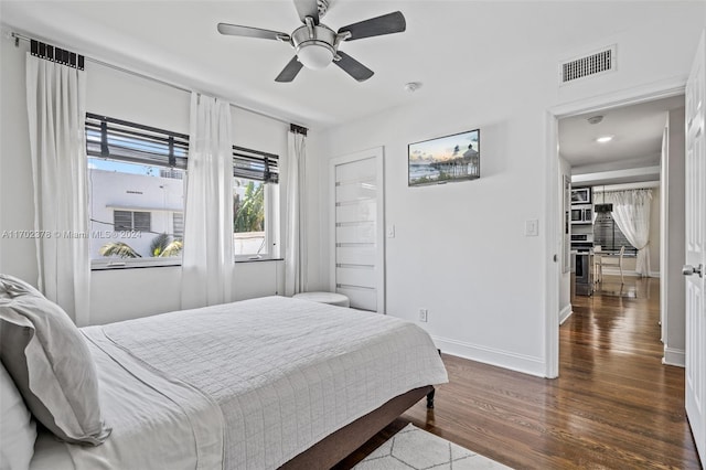 bedroom with ceiling fan and dark wood-type flooring