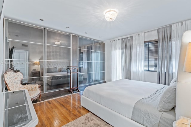 bedroom with a chandelier and hardwood / wood-style flooring