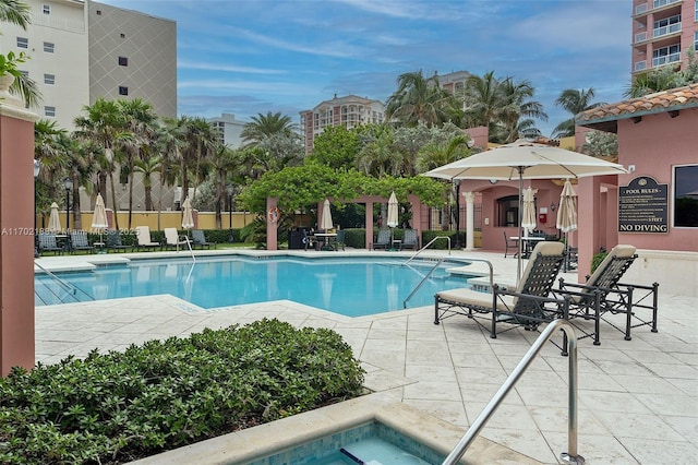 view of swimming pool with a community hot tub and a patio area