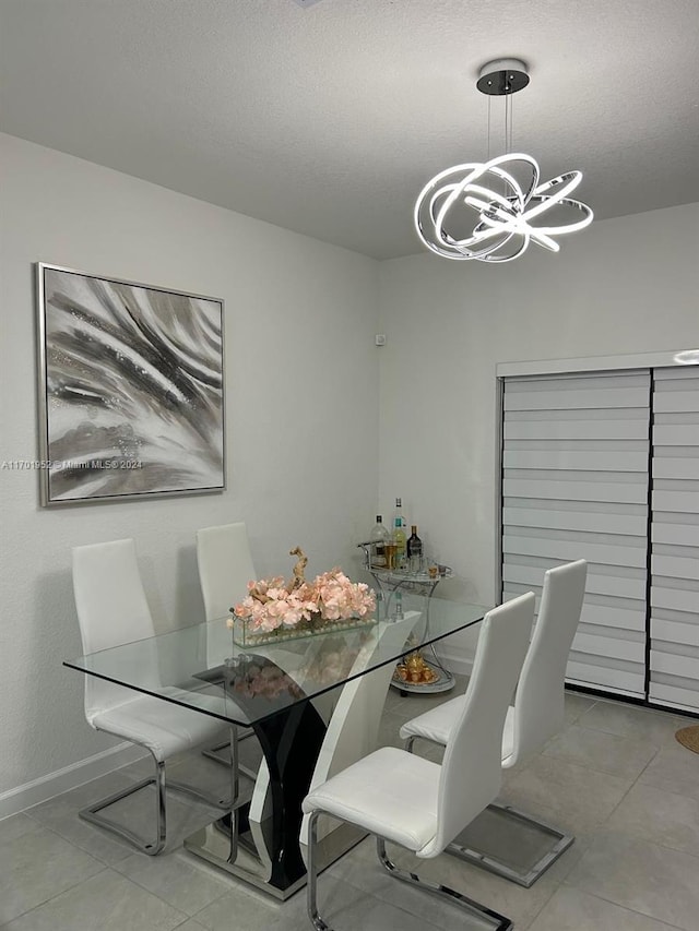 dining area with a textured ceiling and an inviting chandelier