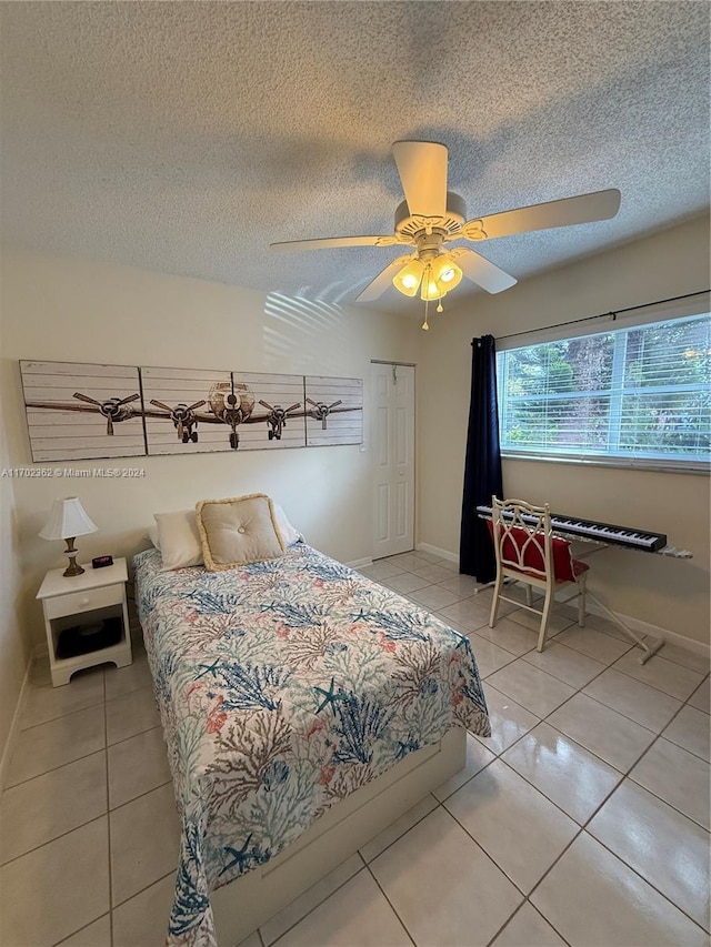 bedroom with tile patterned flooring, a textured ceiling, and ceiling fan