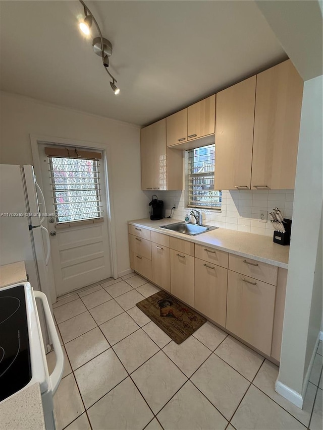 kitchen with decorative backsplash, white appliances, sink, and light tile patterned floors