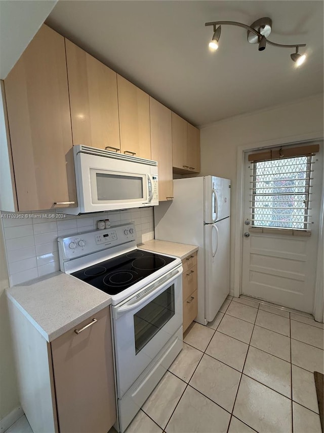 kitchen with tasteful backsplash, light tile patterned floors, and white appliances