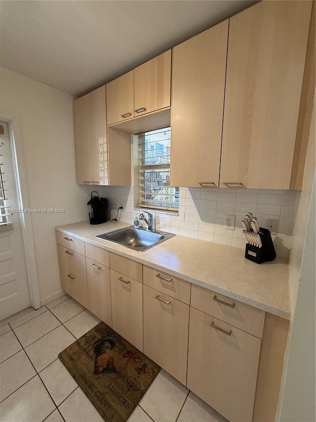 kitchen featuring tasteful backsplash, sink, light tile patterned floors, and light brown cabinets