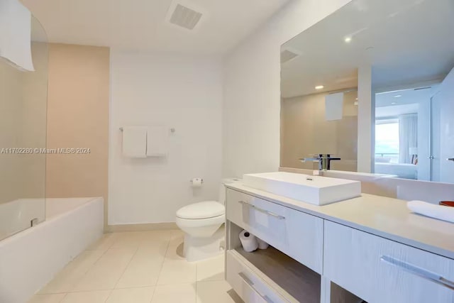 bathroom featuring tile patterned floors, vanity, toilet, and a tub