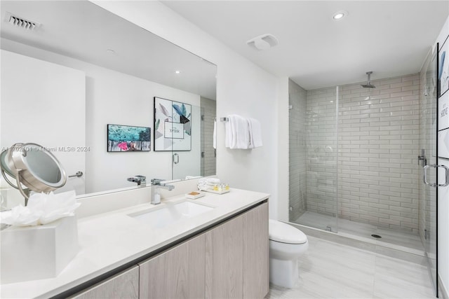 bathroom with tile patterned flooring, vanity, a shower with shower door, and toilet