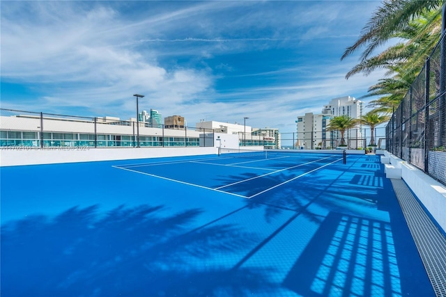 view of tennis court featuring basketball hoop