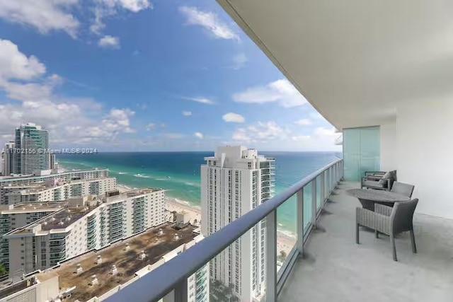 balcony with a water view and a beach view