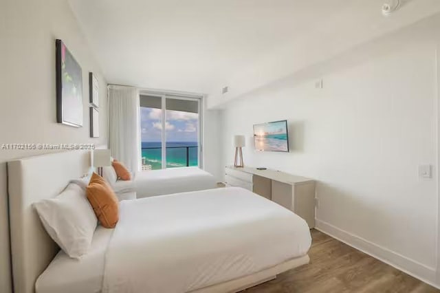 bedroom featuring dark wood-style floors, baseboards, and access to exterior