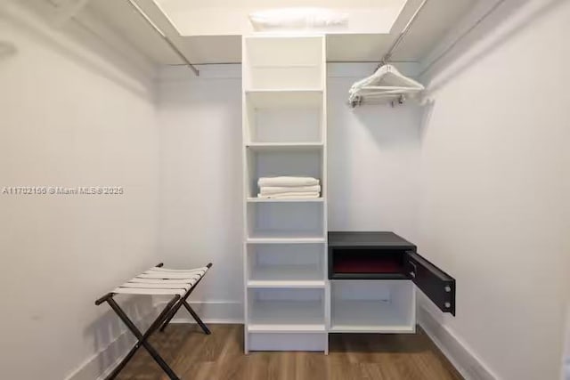 walk in closet with wood finished floors