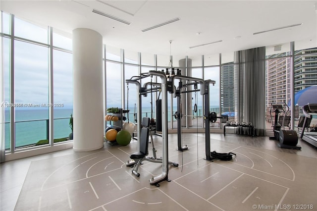 workout area with expansive windows, a water view, and visible vents