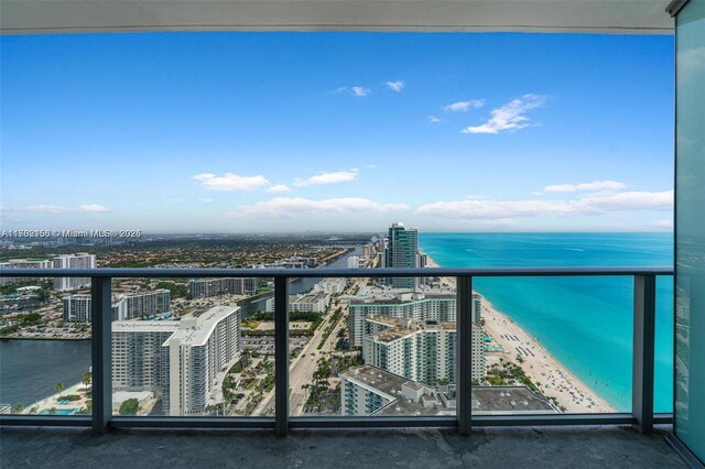 balcony featuring a water view and a view of the beach