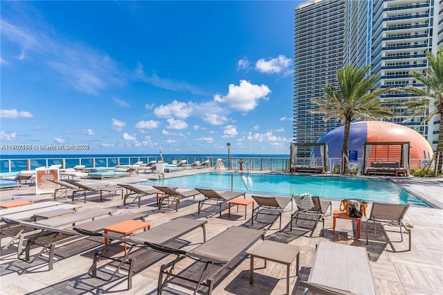 community pool with a water view and a patio area