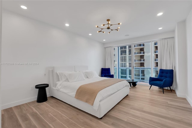 bedroom with an inviting chandelier and light hardwood / wood-style flooring