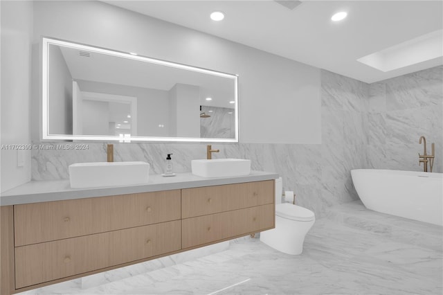 bathroom with a bathtub, toilet, tile walls, and vanity