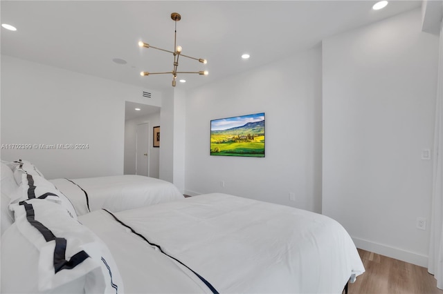 bedroom featuring light hardwood / wood-style floors and a notable chandelier