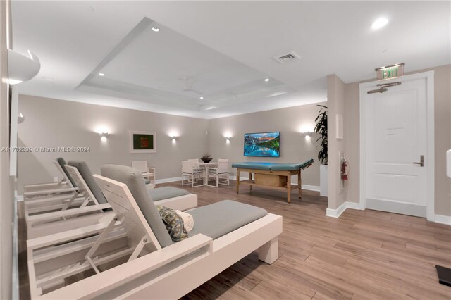 interior space with a tray ceiling, light hardwood / wood-style floors, and pool table