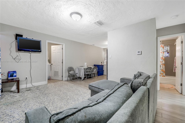 living room featuring a textured ceiling and light wood-type flooring