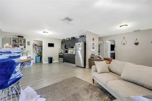 living room featuring a textured ceiling and light wood-type flooring