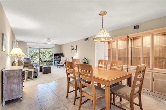 dining space featuring light tile patterned flooring and ceiling fan with notable chandelier