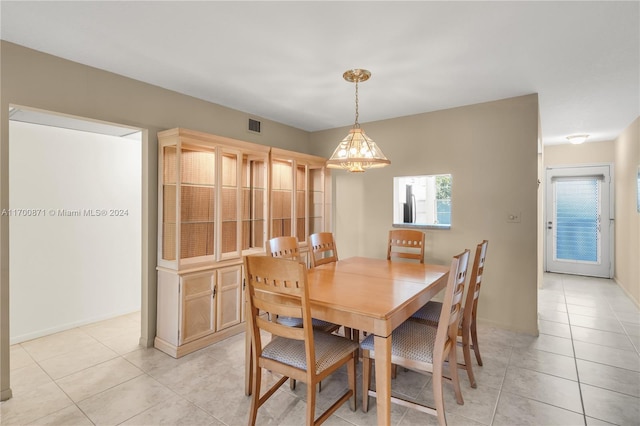 dining area featuring light tile patterned flooring and an inviting chandelier