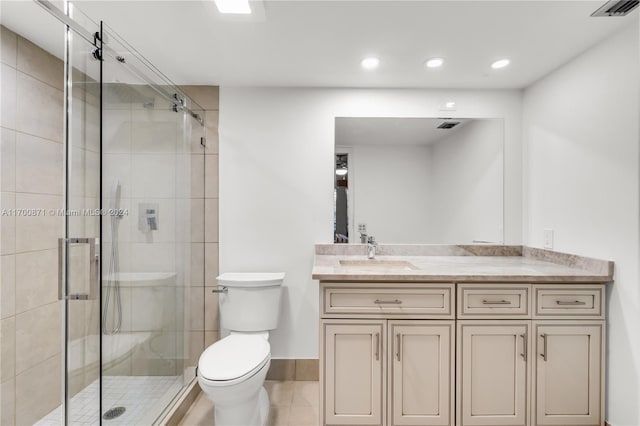 bathroom featuring tile patterned flooring, vanity, an enclosed shower, and toilet