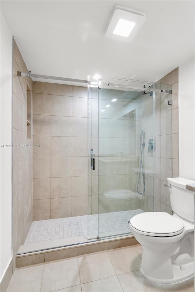 bathroom with toilet, tile patterned floors, and an enclosed shower