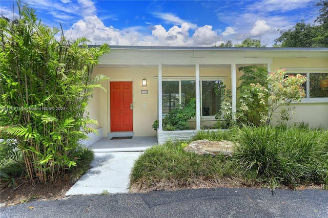 view of exterior entry featuring covered porch