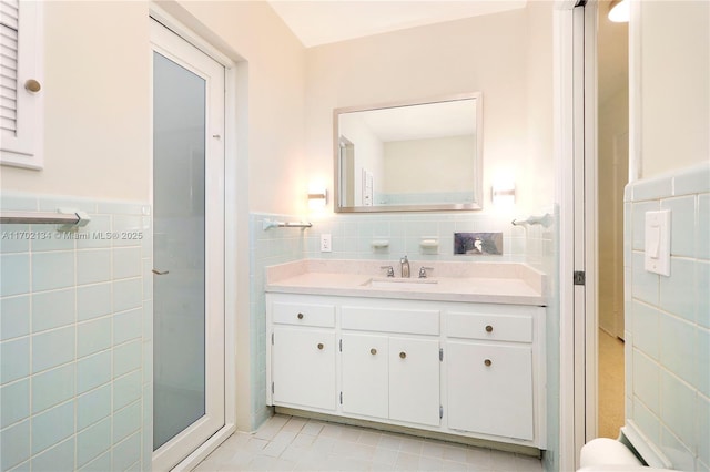 bathroom featuring vanity, tile walls, and a shower