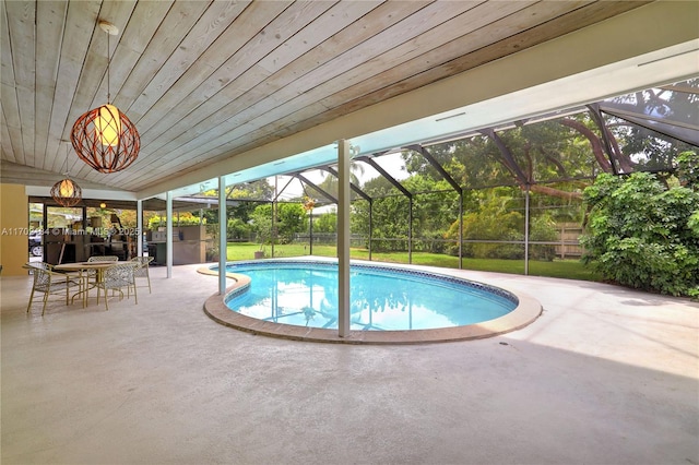 view of pool with a lanai, a patio area, and a lawn