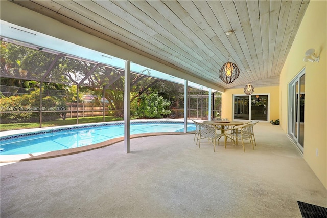 view of pool with glass enclosure and a patio area