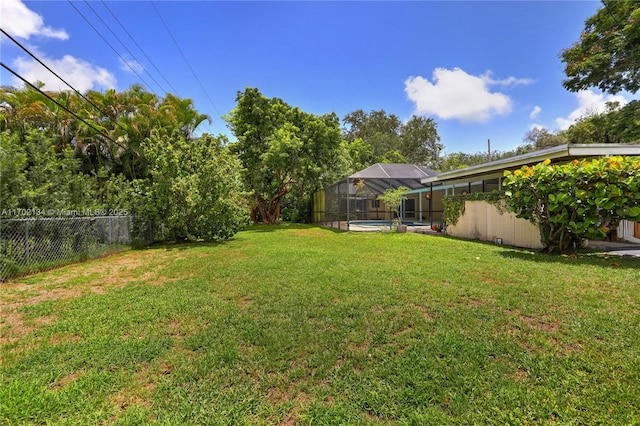 view of yard featuring a fenced in pool and a lanai