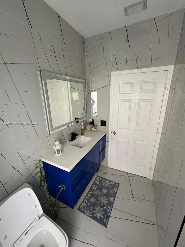 bathroom with vanity and tile walls