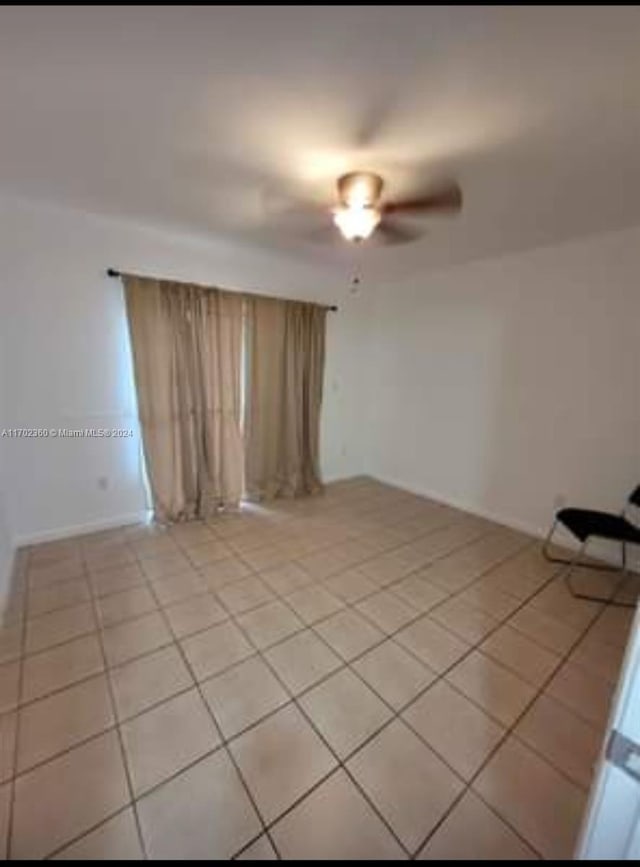 spare room featuring a ceiling fan and light tile patterned flooring