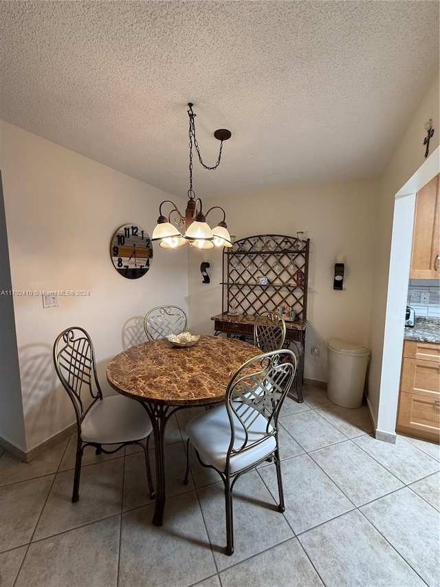 tiled dining area with a textured ceiling and a notable chandelier