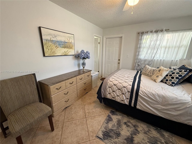 tiled bedroom with a textured ceiling and ceiling fan