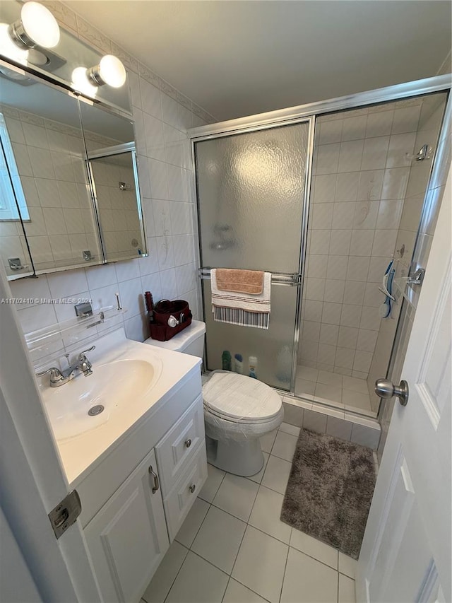 bathroom with decorative backsplash, tile patterned floors, tile walls, and a shower with shower door