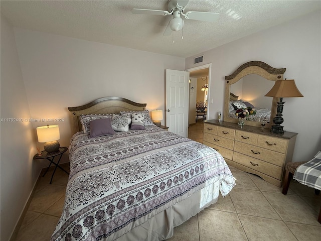 tiled bedroom featuring ceiling fan and a textured ceiling