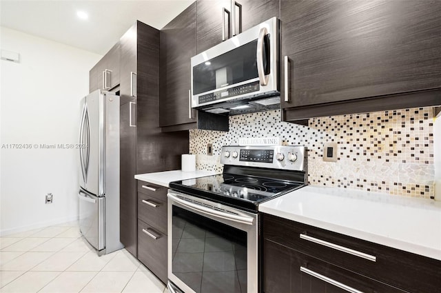 kitchen featuring dark brown cabinets, light tile patterned floors, stainless steel appliances, and tasteful backsplash