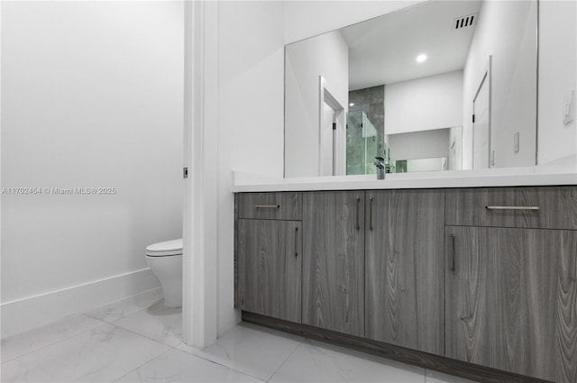 bathroom featuring vanity, toilet, and a shower with door